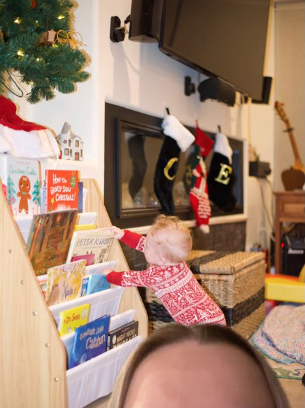 The son of pediatrician Dr. Em next to the Christmas stocking hanging on the wall in the background as an example of the security of the decoration